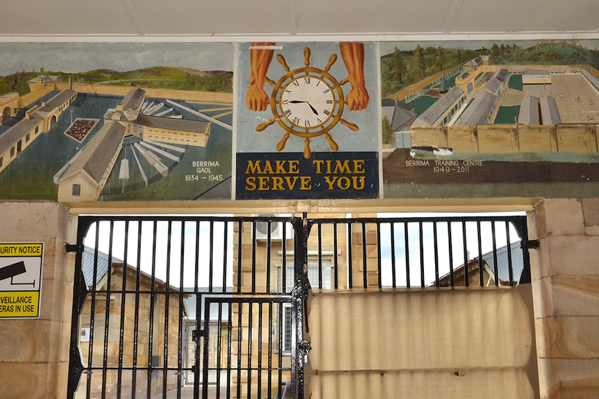 The entrance to Berrima Correctional Centre, with a mural above the entrance that says 'Make time serve you'.