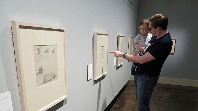 Father and child look at Winnie the Pooh drawings