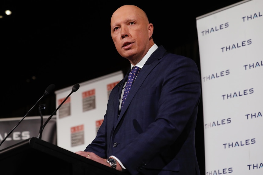 Peter Dutton speaks at a lecturn in front of a Thales defence banner