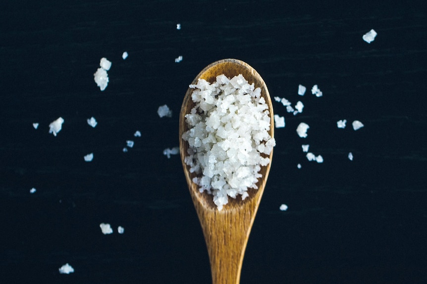 pieces of rock salt on a wooden spoon