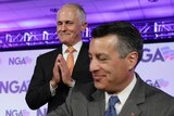 Malcolm Turnbull smiles and holds his hands together with Nevada Governor Brian Sandoval sitting in front of him.