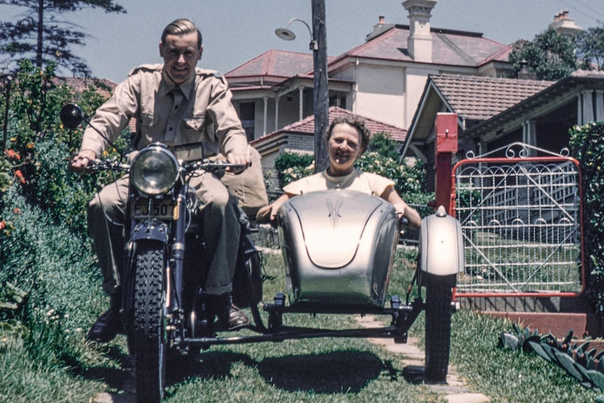 A man and a woman riding a motorcycle with a sidecar.