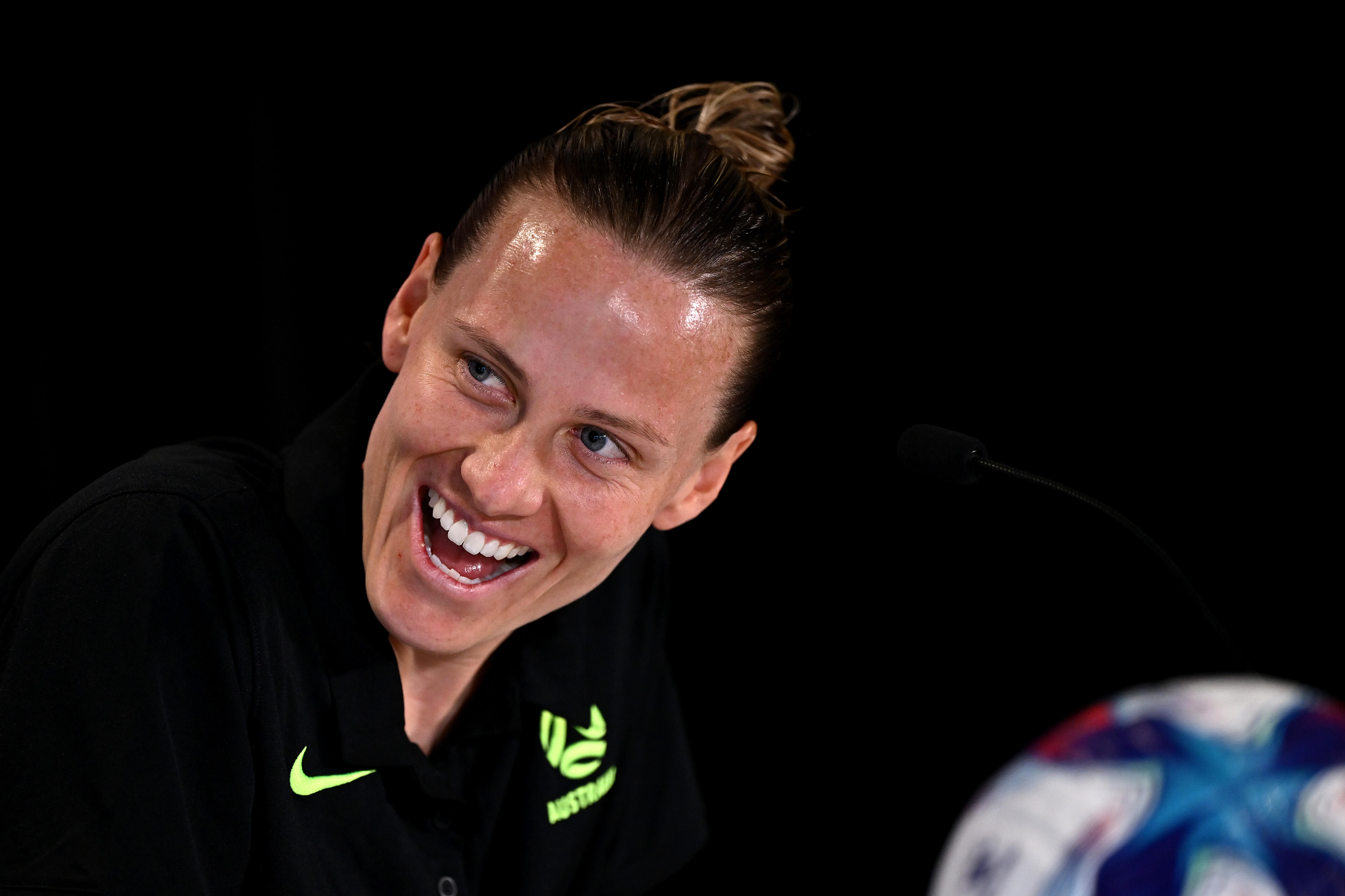 Um close do rosto de Emily van Egmond enquanto ela ri durante uma entrevista coletiva.