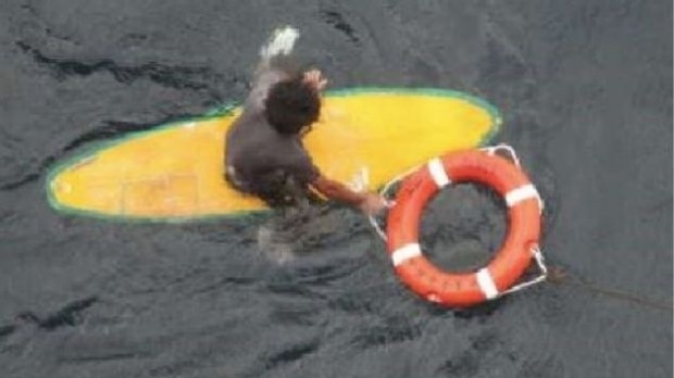 A man on a surfboard with a life ring.