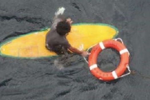 A man on a surfboard with a life ring.