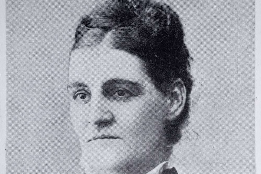 A black and white photo of an unsmiling woman.