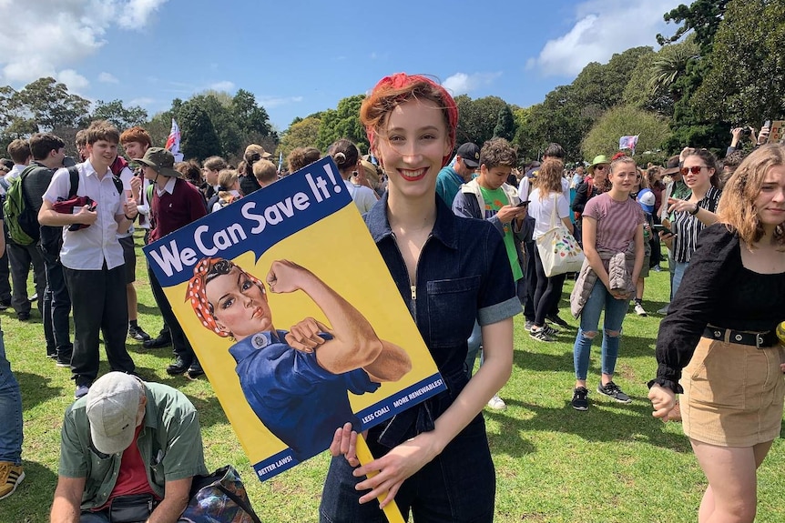 A young woman holds a sign at a climate rally in Sydney