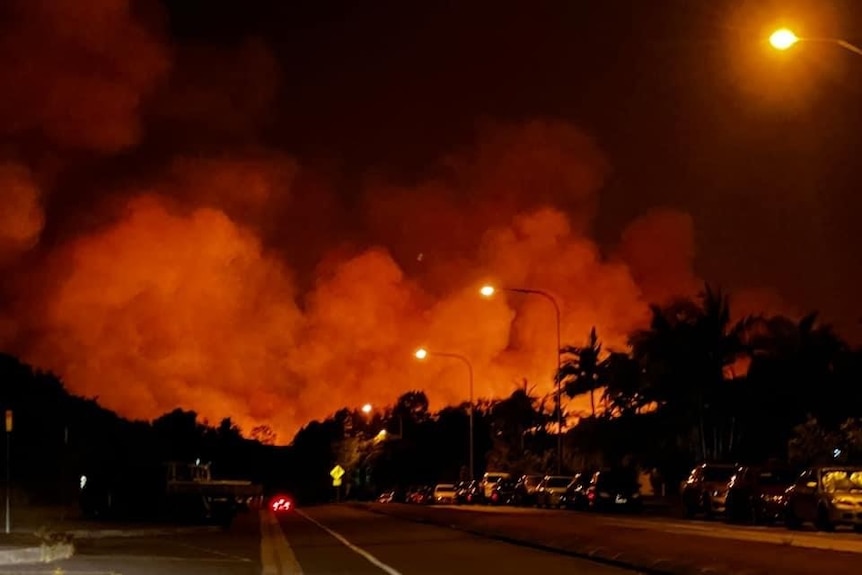 Large plumes of smoke and fire, orange coloured in night sky