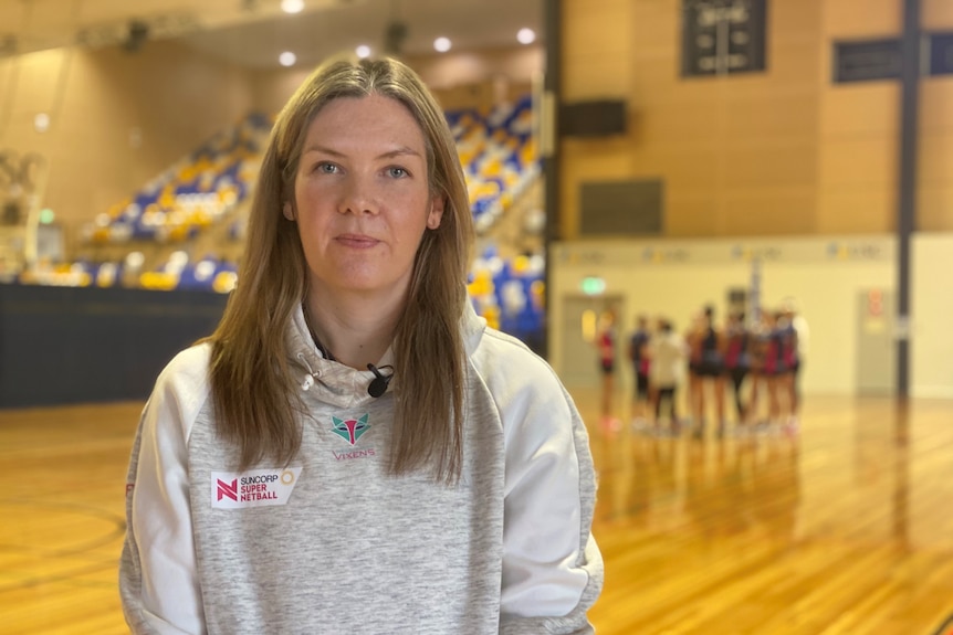 Woman stands on netball court 