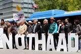 Protesters hold letters reading "No THAAD".