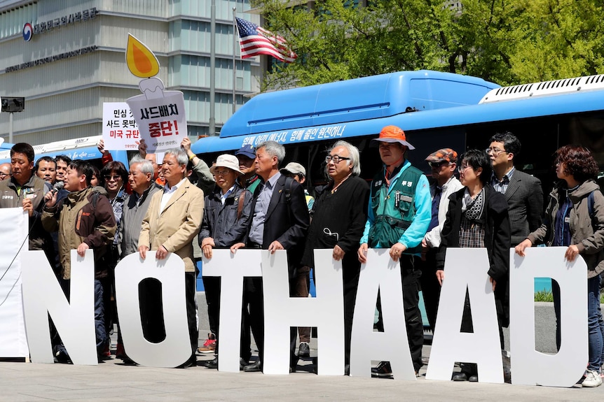 Protesters hold letters reading "No THAAD".