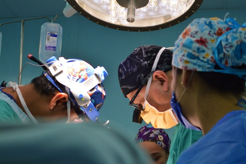 Three surgeons work together in a hospital.