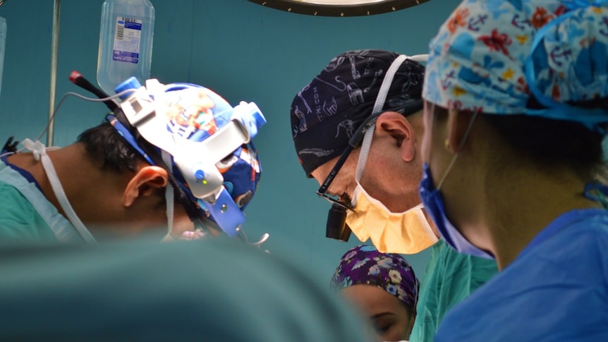 Three surgeons work together in a hospital.