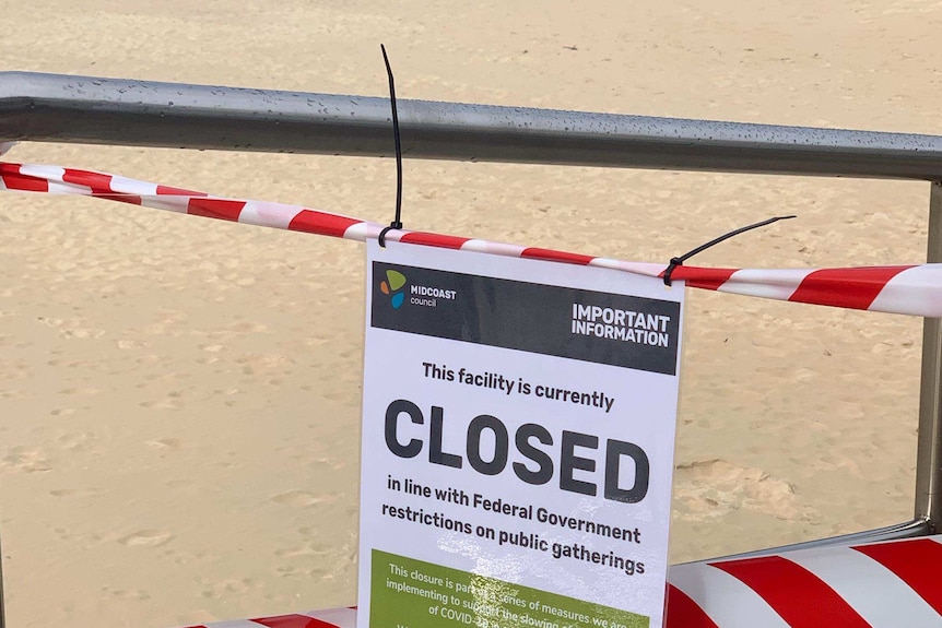 MidCoast Council sign on beach railing indicating the beaches are closed