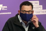 Victorian Premier Daniel Andrews arrives in a mask to speak to the media during a press conference in Melbourne