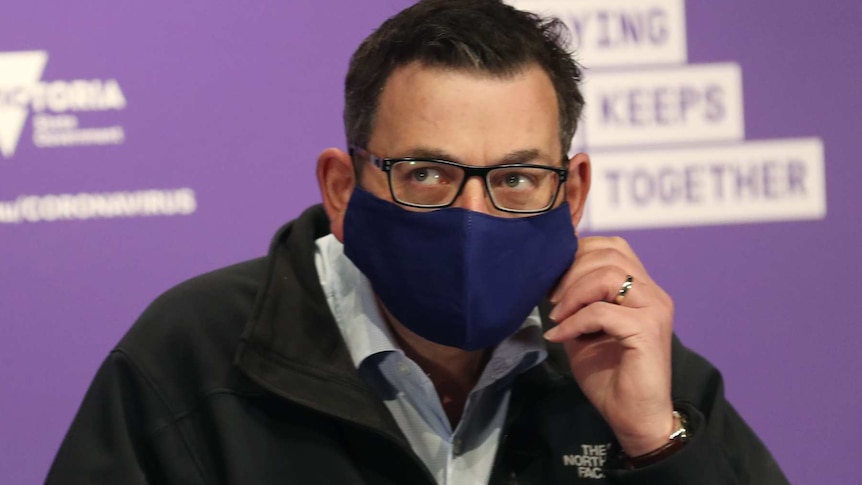 Victorian Premier Daniel Andrews arrives in a mask to speak to the media during a press conference in Melbourne