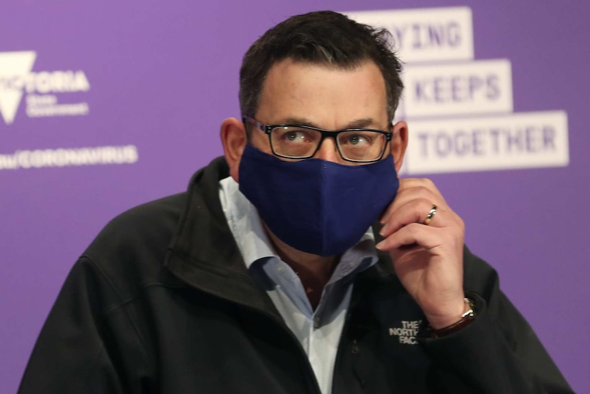 Victorian Premier Daniel Andrews arrives in a mask to speak to the media during a press conference in Melbourne