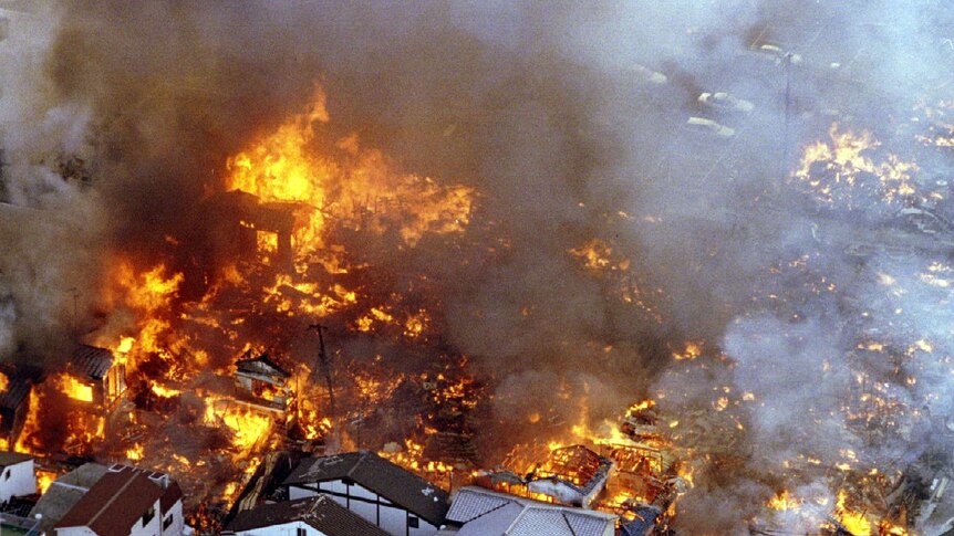 Houses lie in flames as a fire cuts through a Kobe city block following an earthquake