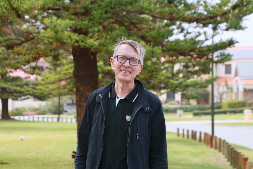 Professor Kingsley Dixon in front of a Norfolk pine tree.