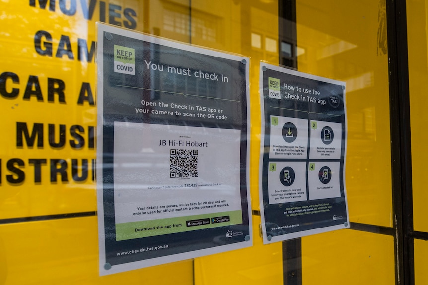 QR check in signs outside a shopfront.
