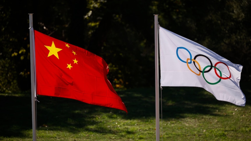 The flags of China and the International Olympic Committee flying on a flagpole