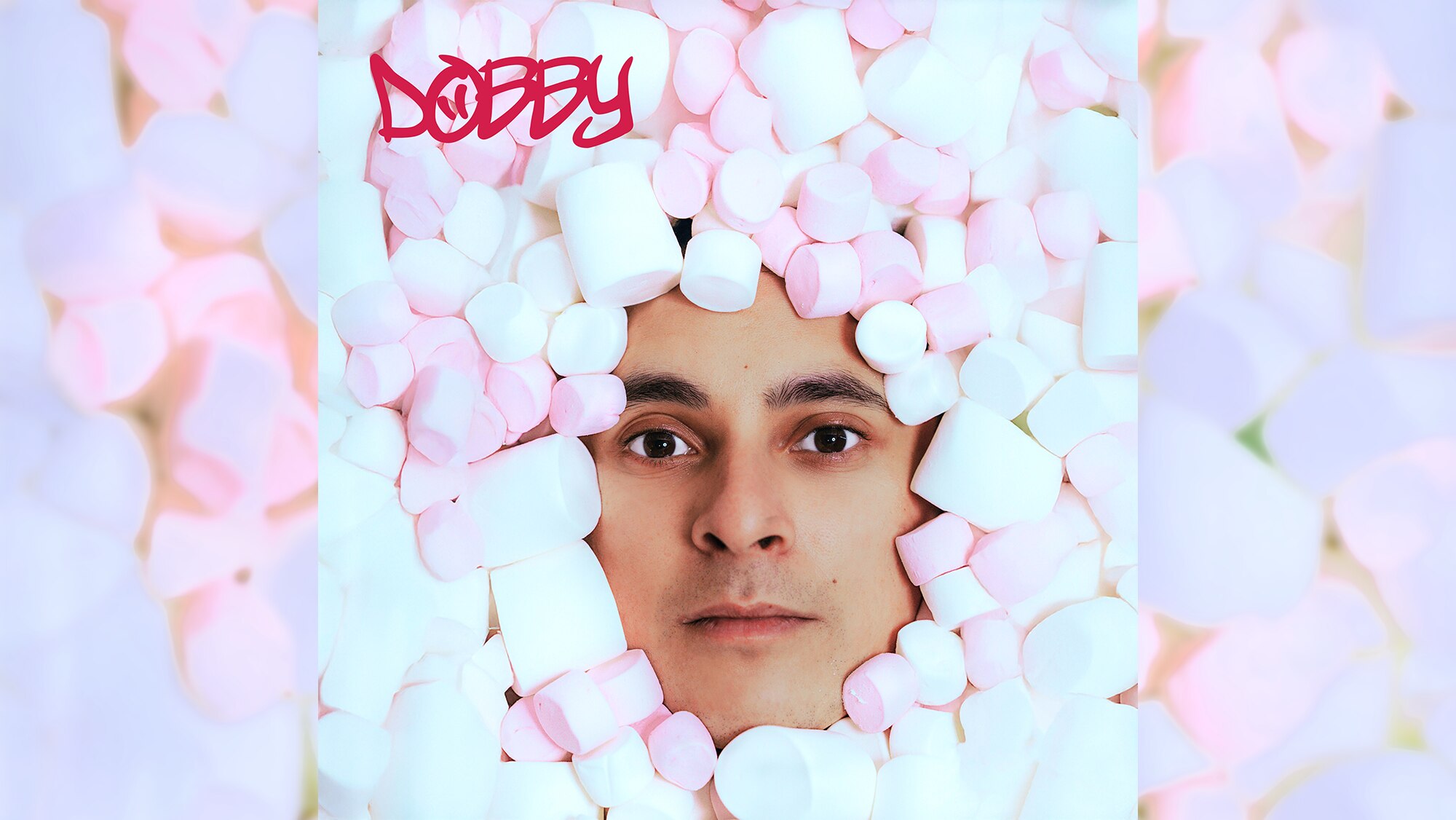 Face of Filipino/First Nations man peering out of a pile of white & pink marshmallows. Red text reads: DOBBY