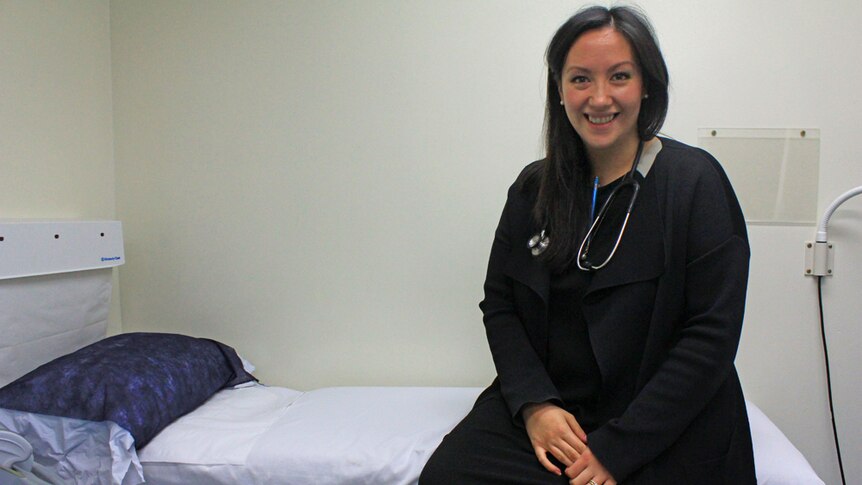 Michelle sitting on the consultation bed in her Glenden practice