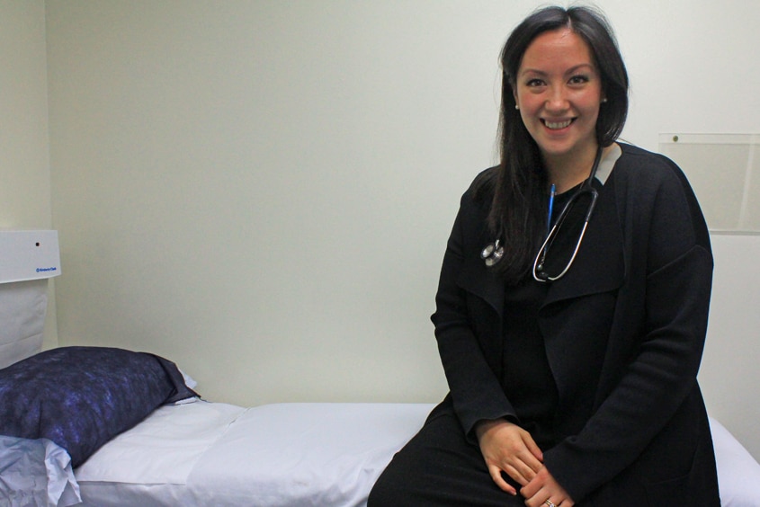 Michelle sitting on the consultation bed in her Glenden practice