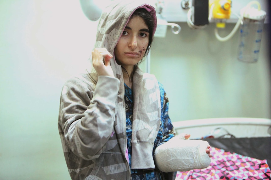 A displaced woman receives treatment after being injured in clashes.