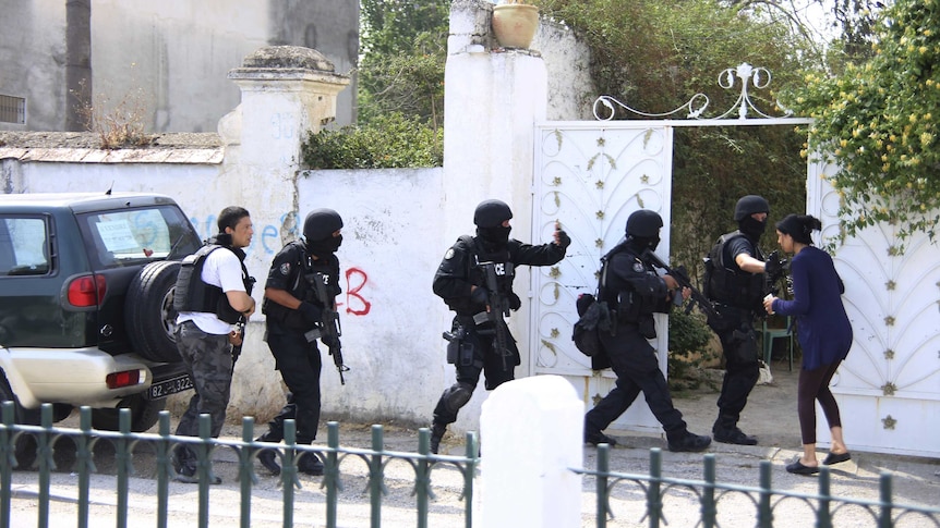 Tunisian anti-terrorism brigade personnel enter a house to take position