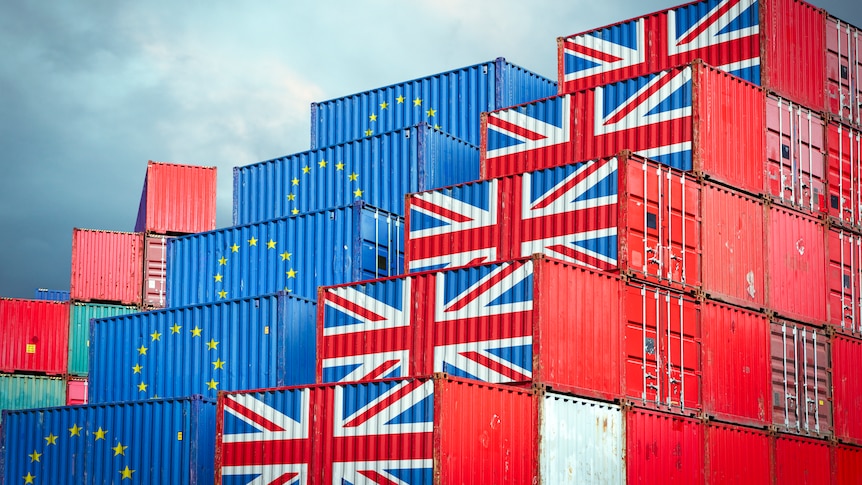 stacked shipping containers bearing the flags of the UK and the EU