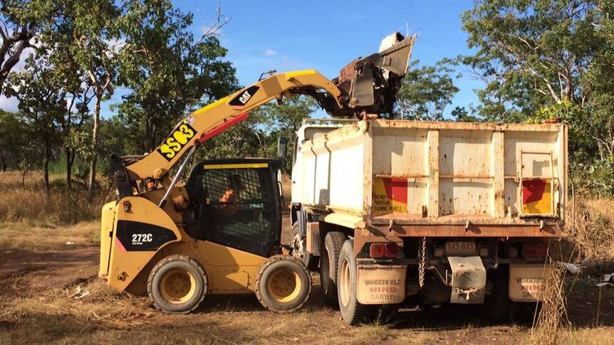 A member of the community using machinery to clean up the dumping