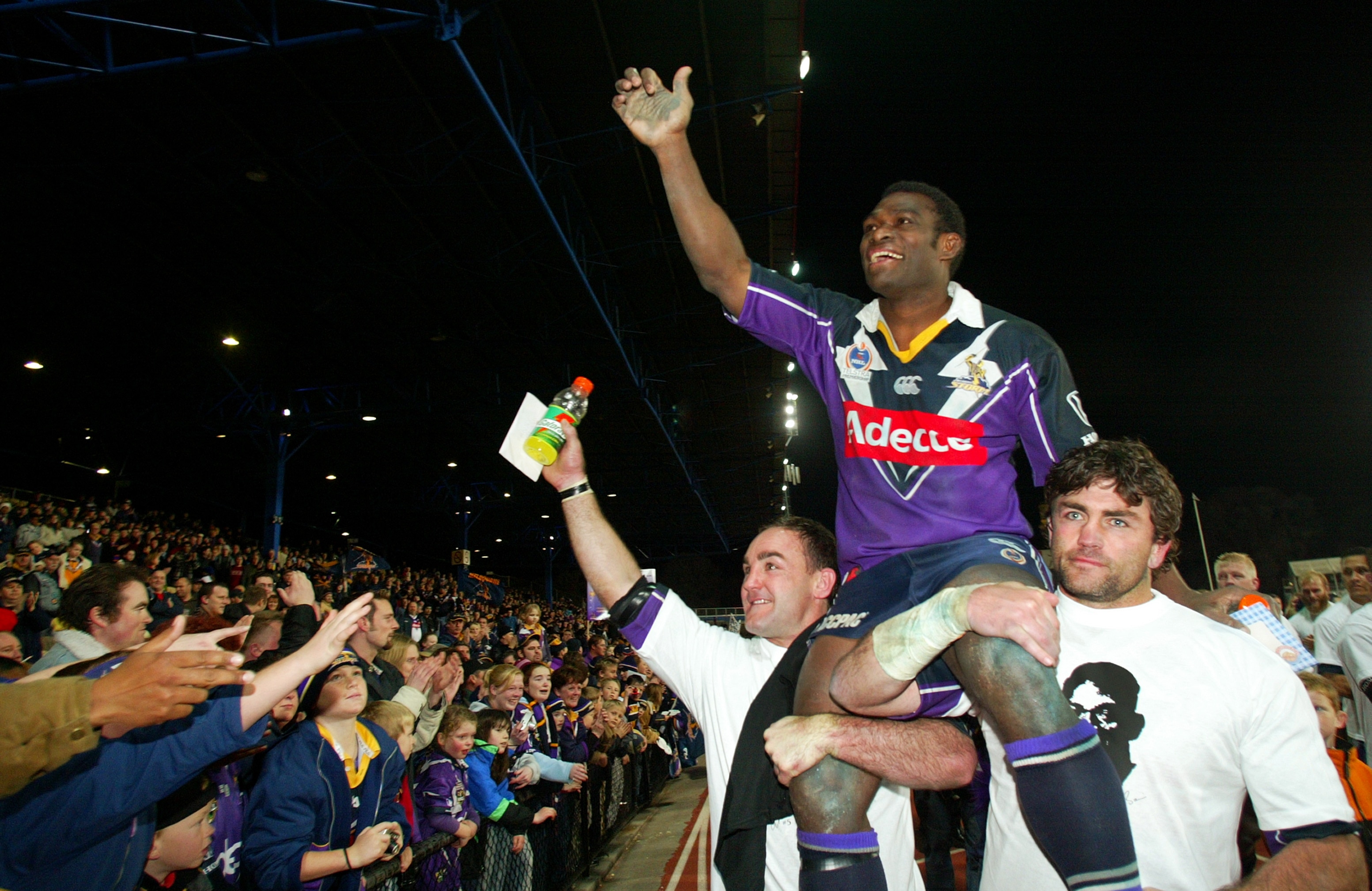 Marcus Bai waves to the crowd while being chaired off 