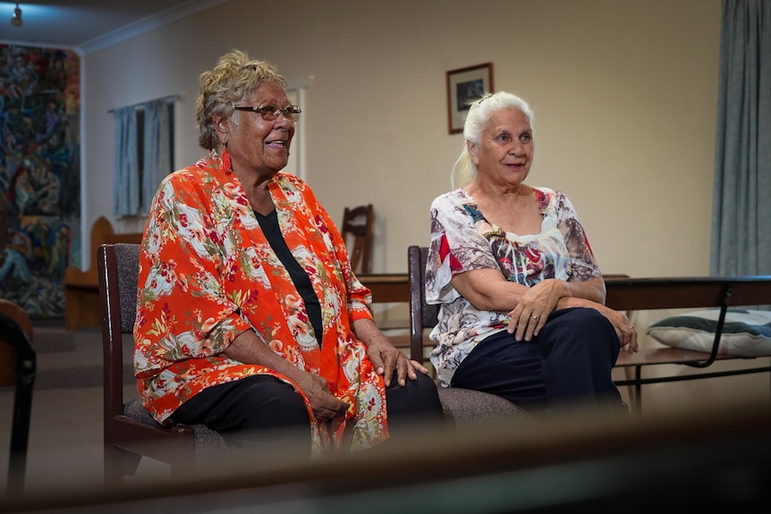 Two women sit smiling together