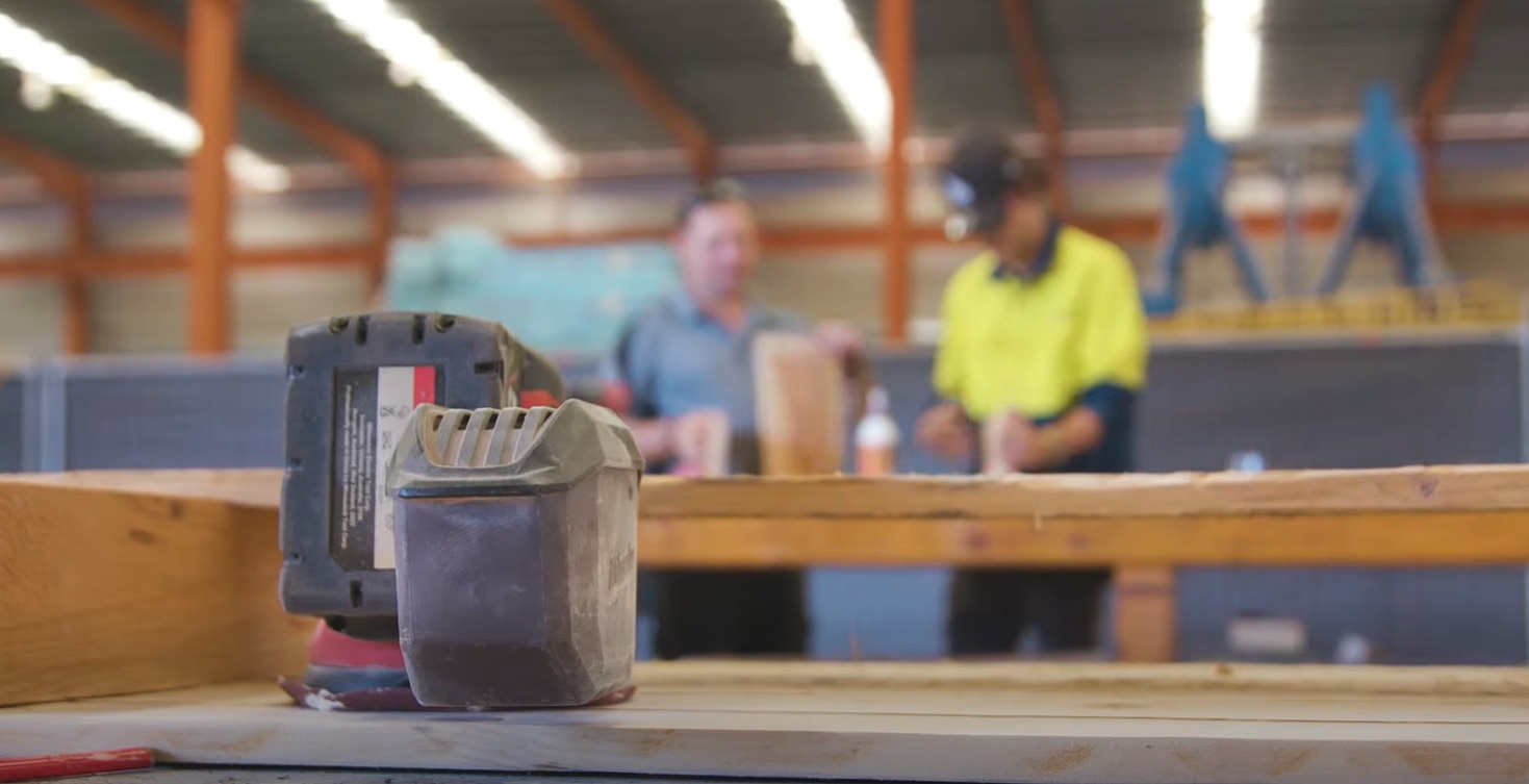 Uma imagem focada de uma ferramenta, com uma silhueta desfocada no fundo de um professor e um aluno com tecnologia de material de aprendizagem de alta visibilidade.