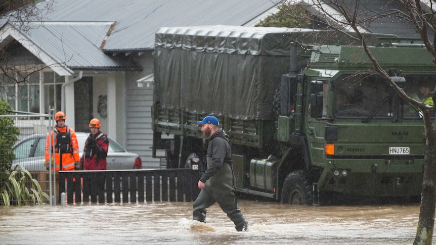 Emergency service workers stand in a flooded street of Christchurch