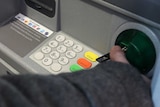 Man puts card into ATM machine