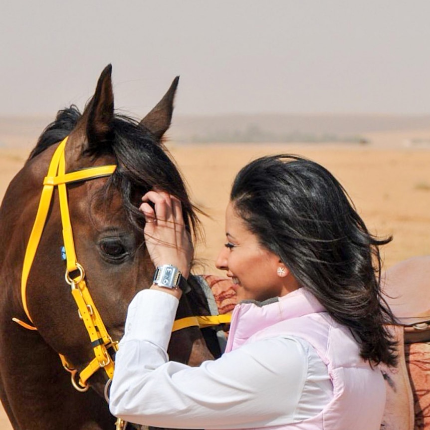 A woman patting a horse