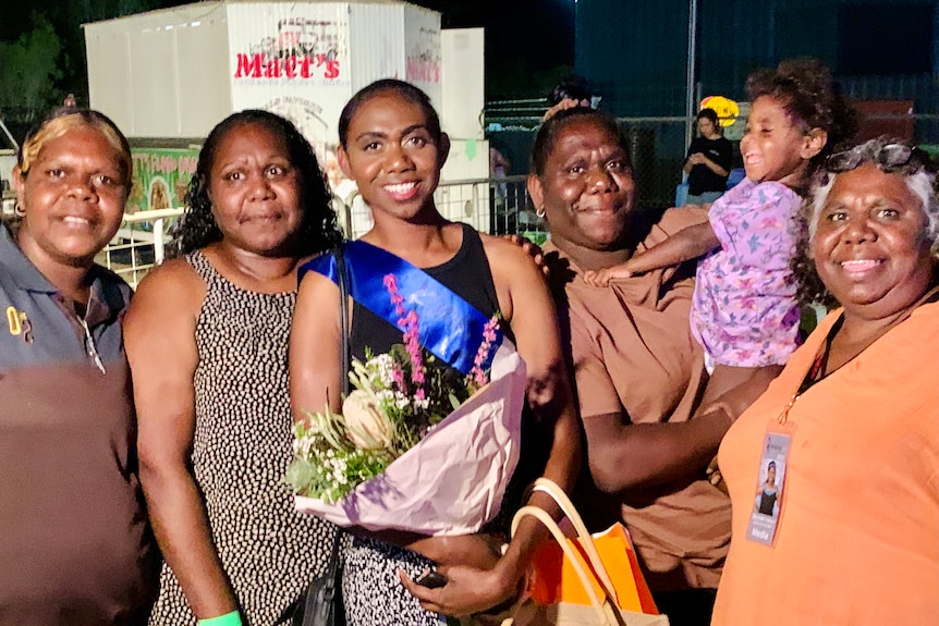 A family group smiles happily at the camera