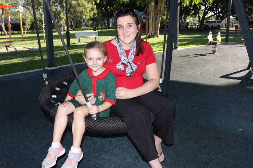 A mother and daughter on a tyre swing