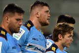 Waratahs players stand in a row looking tired after the Brumbies score a Super Rugby try against them.