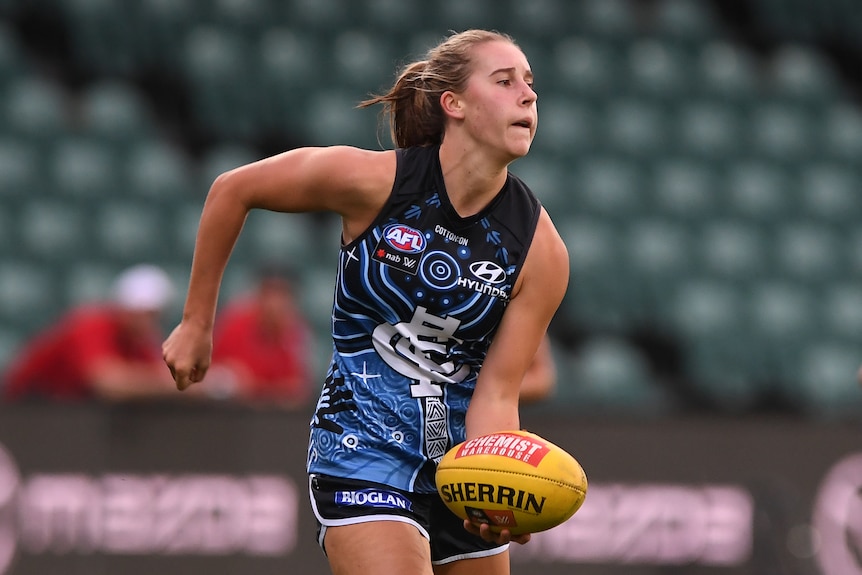 Mimi Hill of Carlton handballing the footy against the Roos in 2021.