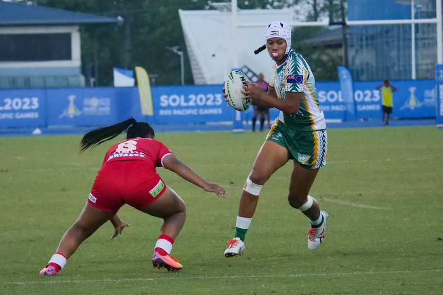 A Cook Islands player dodges a Tongan player in the women's rugby 9s.