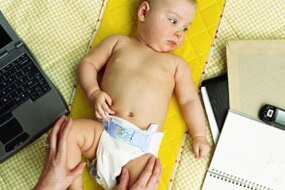 File photo: Baby girl lying by mother, laptop, diary and mobile phone (Getty Creative Images: Photodisc)