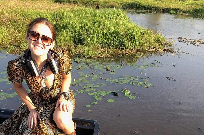 Pippa Ainsworth crouches next to a crocodile