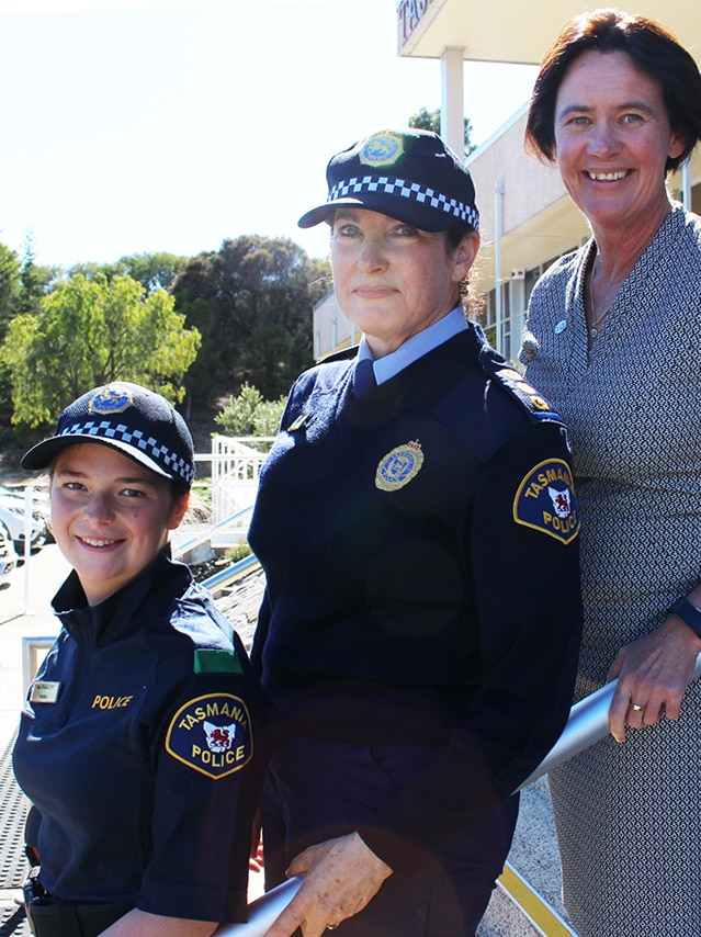 Three female police officers standing on steps.