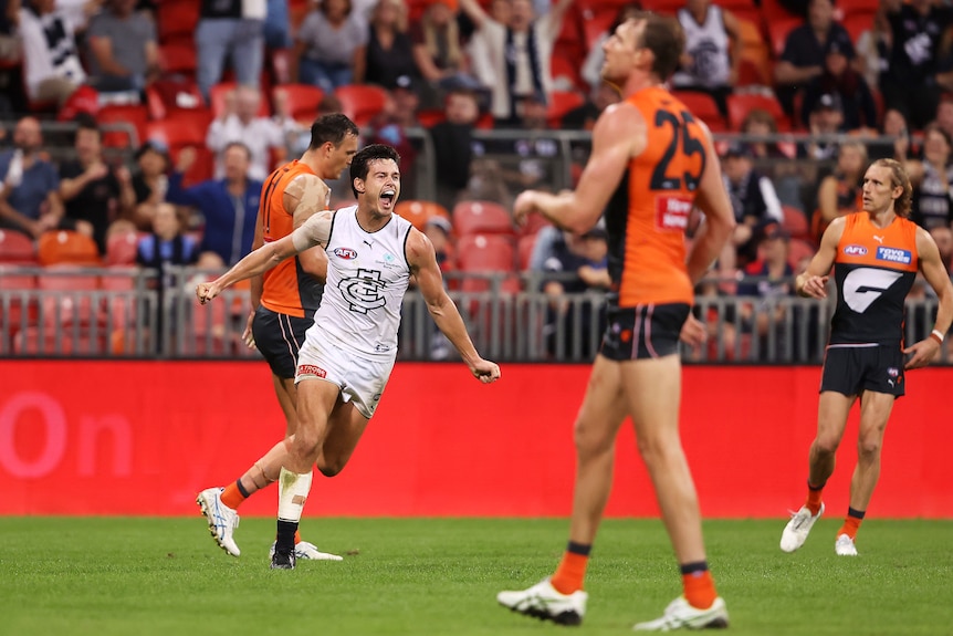 Jack Silvagni yells in delight as Giants players look disappointed