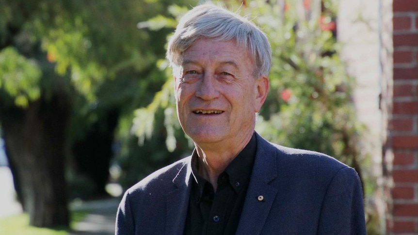 Peter Newman standing on a footpath in the sunshine.