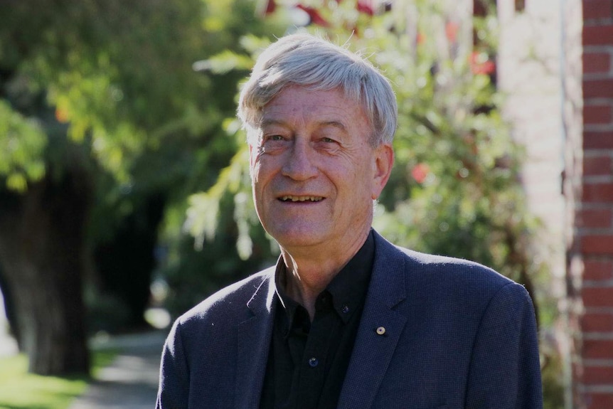 Peter Newman standing on a footpath in the sunshine.