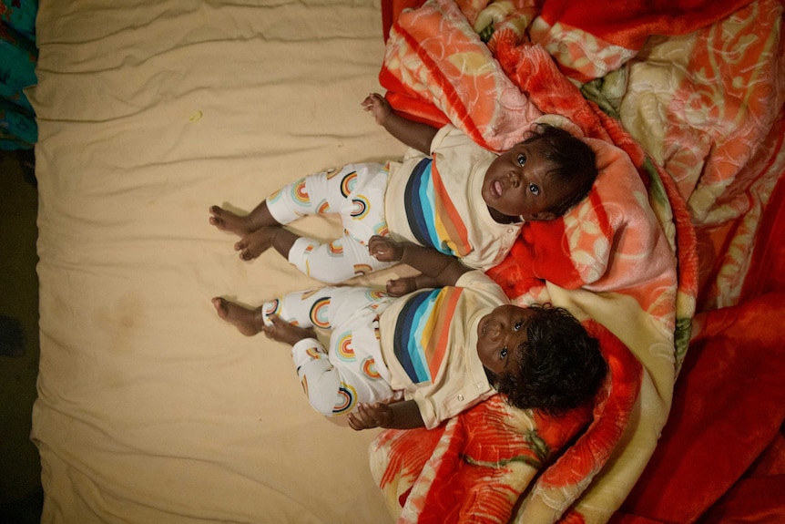 Baby twins Eva and Ava Wanambi on a mattress in a house in Birritjimi community.